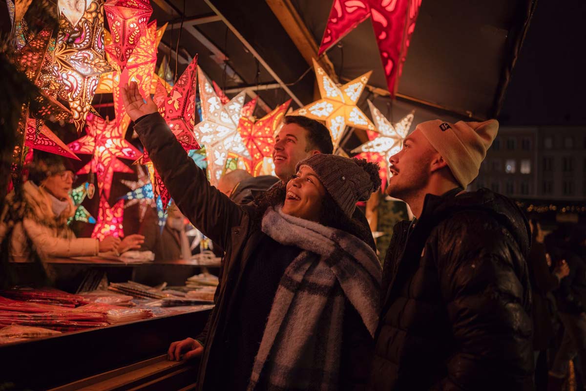 Group Of Friends Having A Look At A Star Ornamnet In A Market