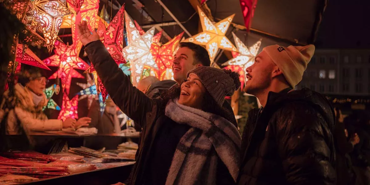 Group Of Friends Having A Look At A Star Ornamnet In A Market