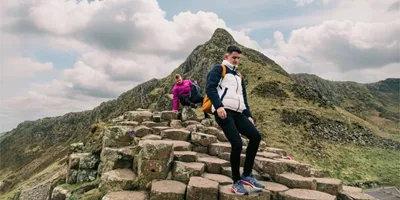 Travellers explore the Giant's Causeway, with its iconic basalt columns and dramatic coastal landscape, on the Contiki Best of Great Britain & Ireland Tour