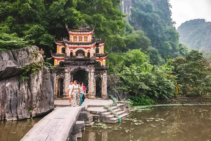 Group Of Young People Walking Close To Temple Gates