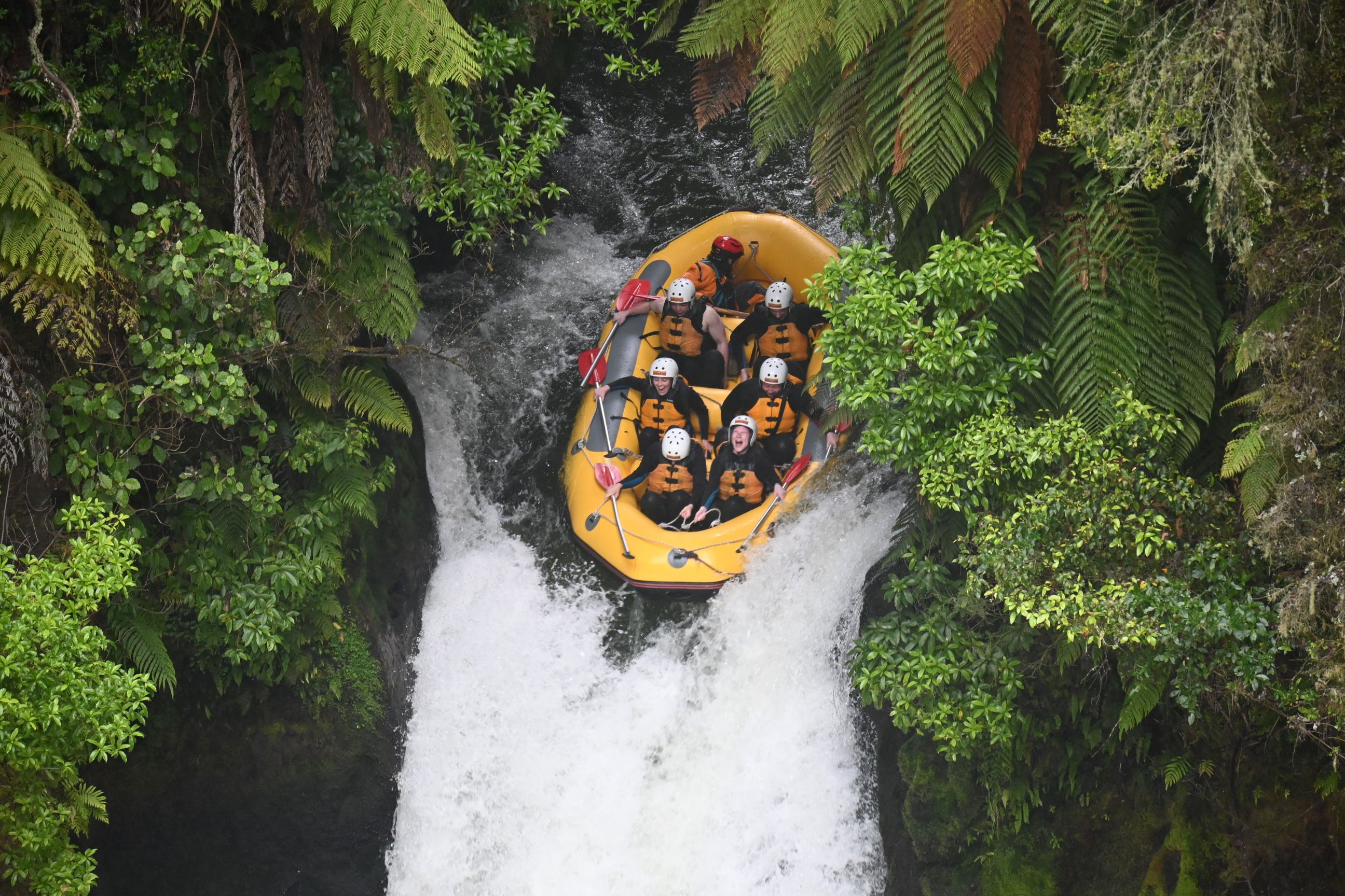 Travellers rafting down a waterfall in Kaituna, Rotorua, New Zealand