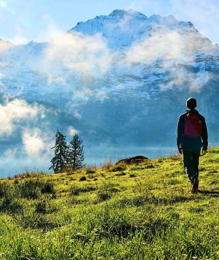 Traveller hiking through the Austrian Alps with panoramic mountain views on the Contiki Active Austrian Alps Tour