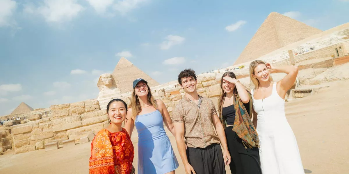 Group Of People Smiling Pyramids As Background
