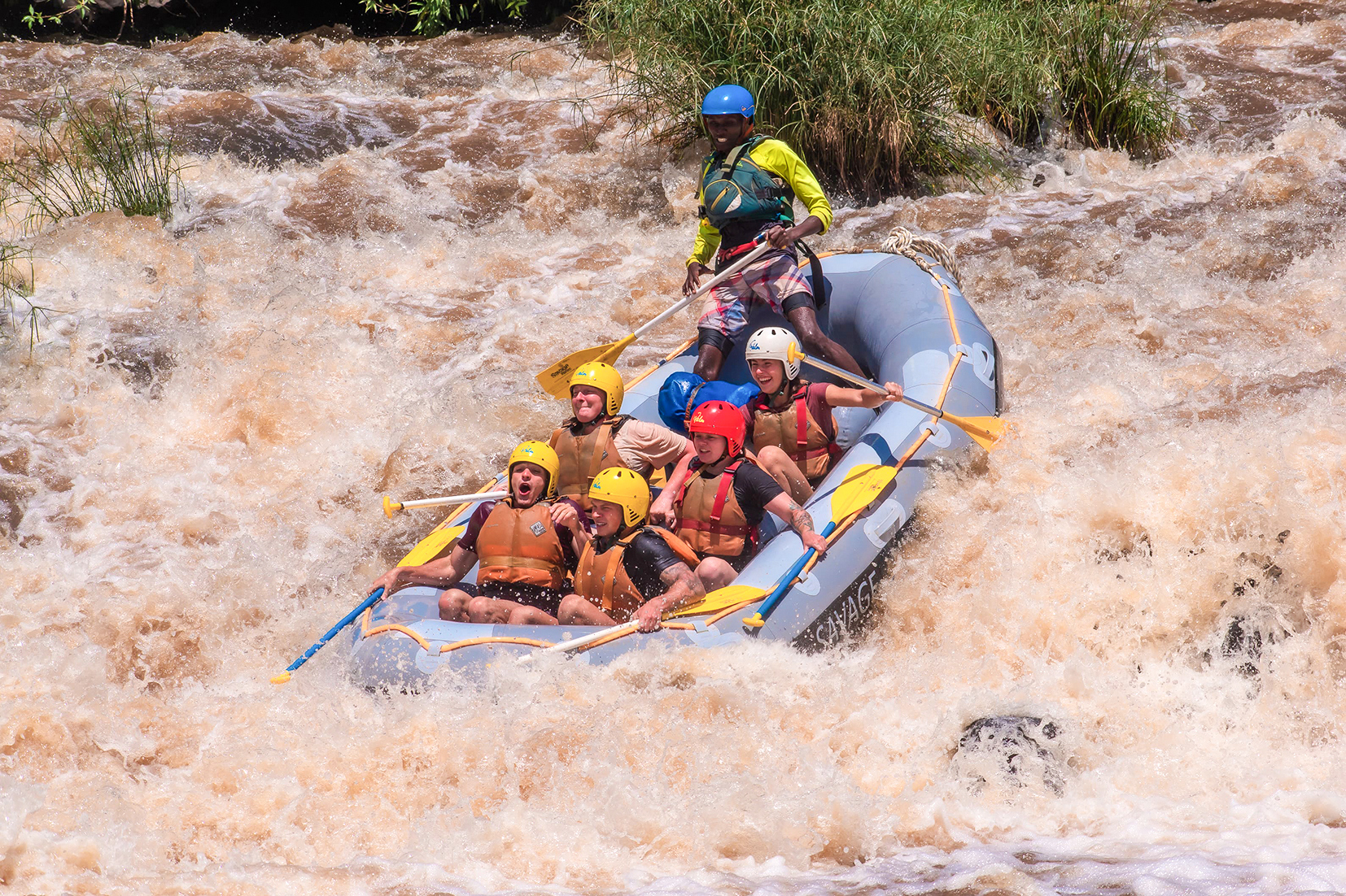 Group of travellers sitting in a raft going down a rapid in Sagana, Kenya