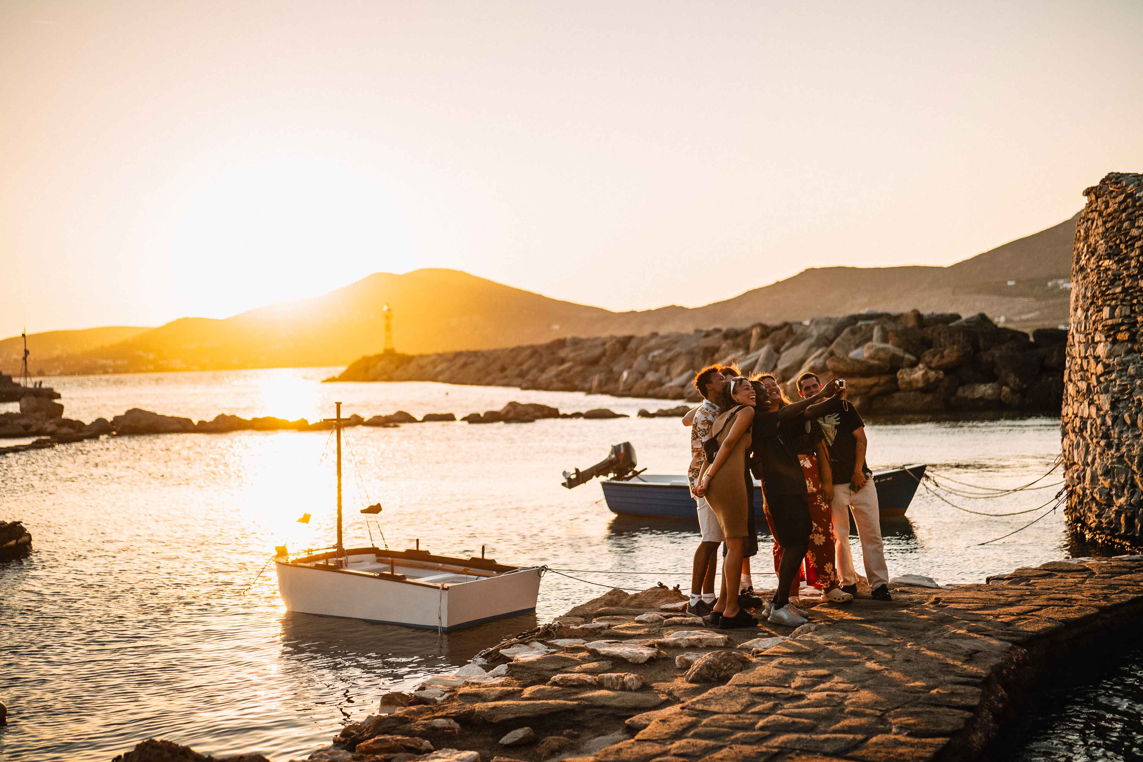 Group Of Young Travelers Taking Selfie At Sunset In Greece