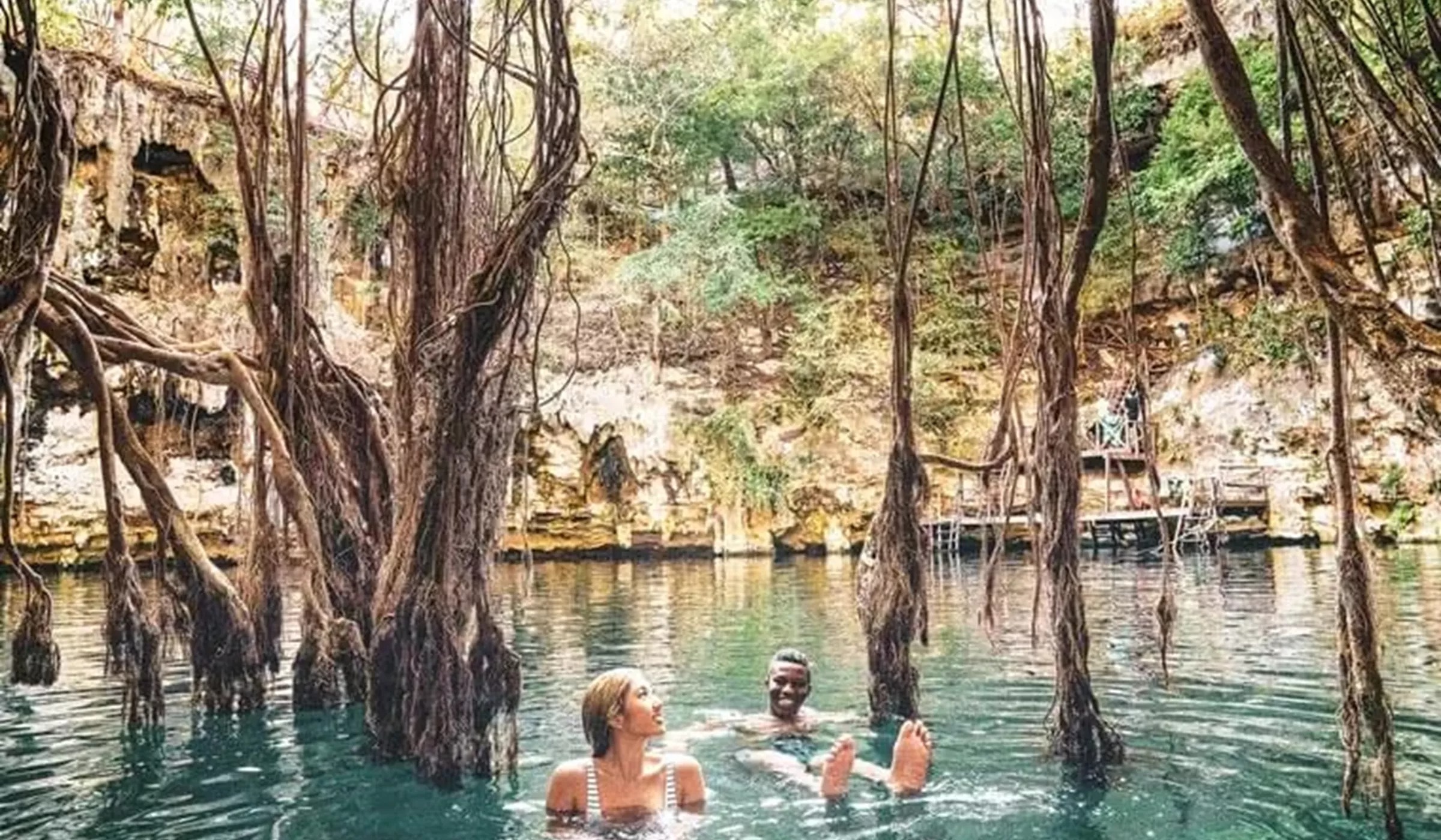 Two people swimming in tropical lake under mangroves 