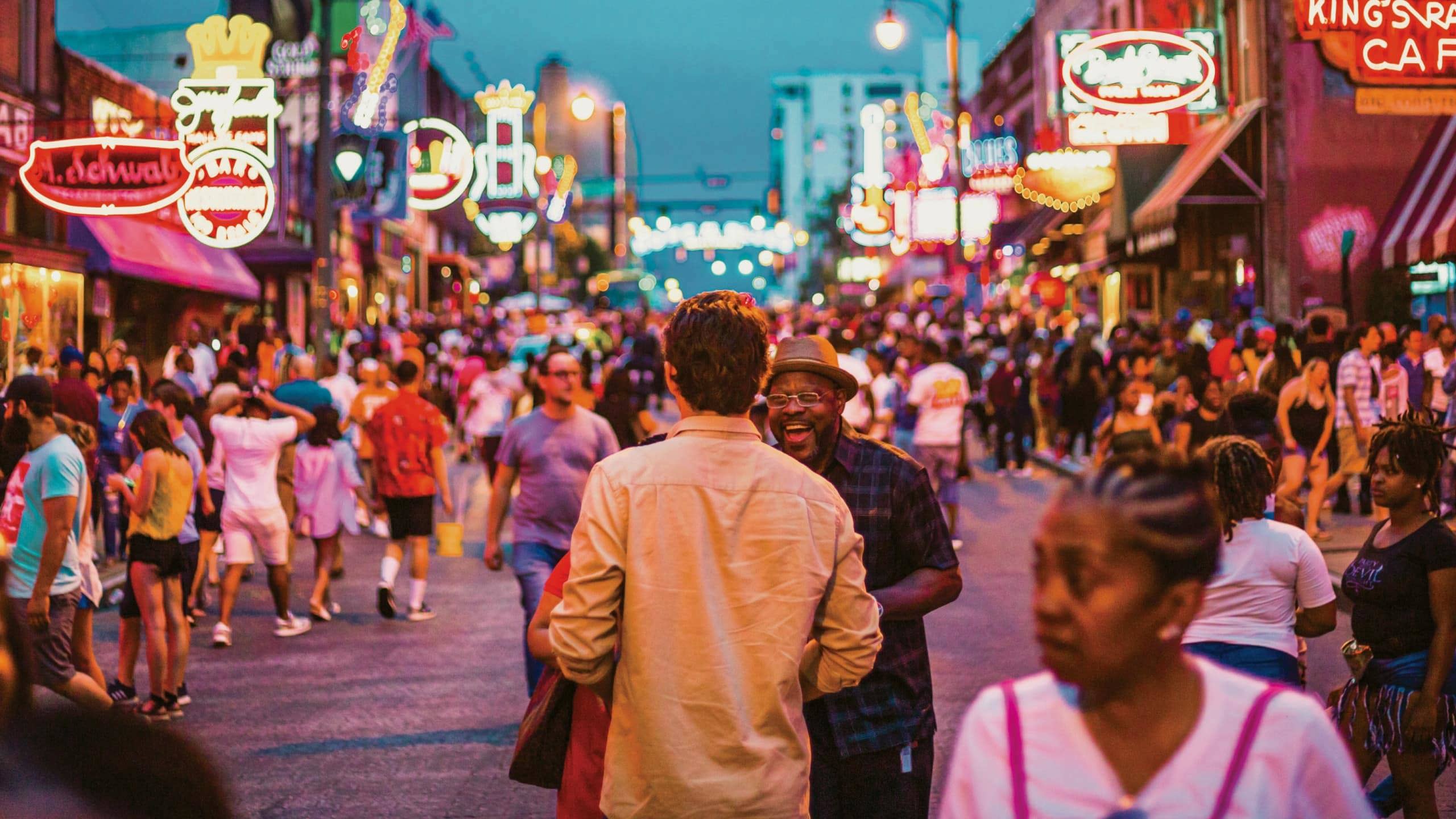 Contiki travellers exploring Broadway in downtown Nashville, Tennessee, surrounded by live music venues and neon signs on the Nashville to Dallas Tour