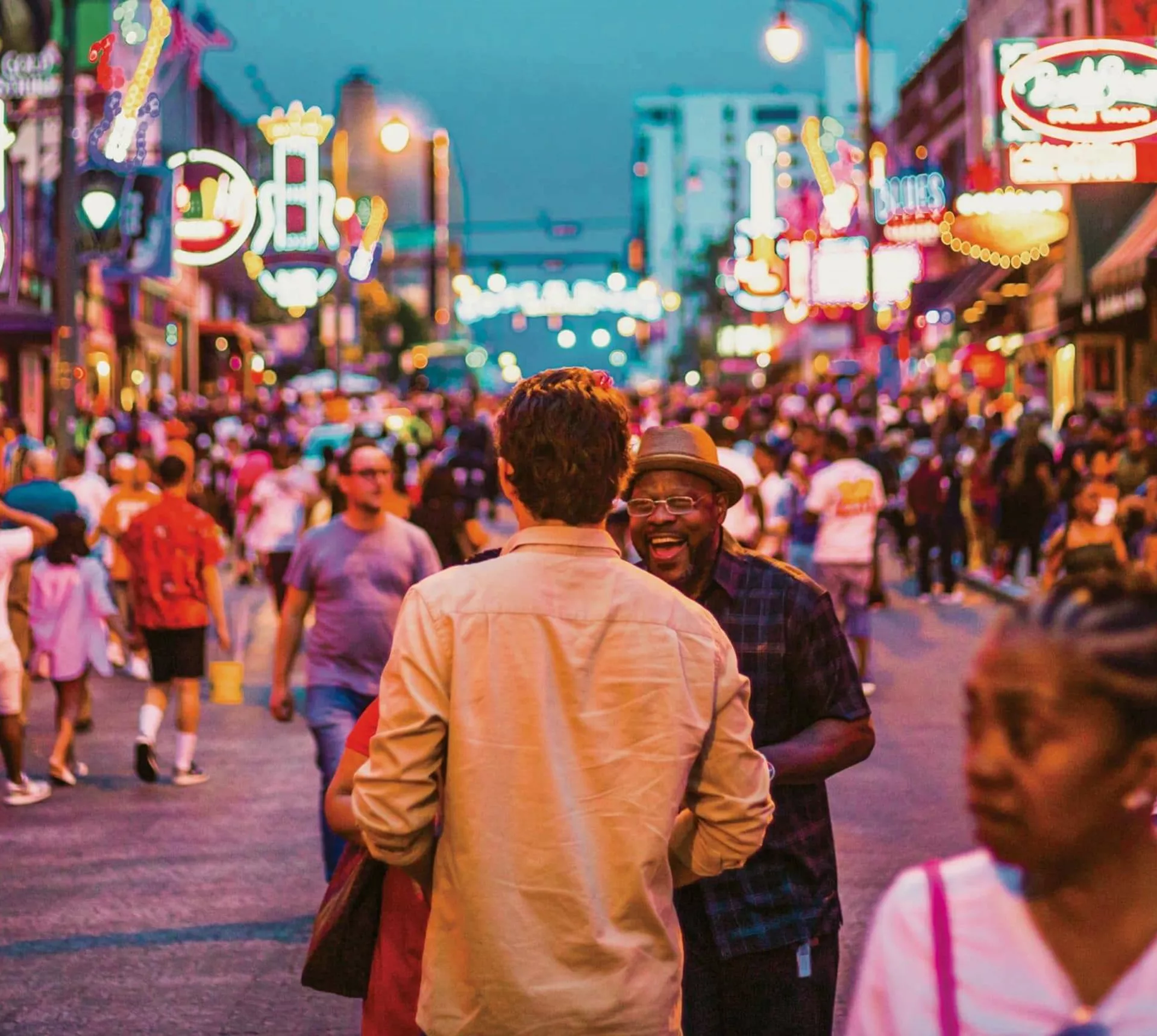 Contiki travellers exploring Broadway in downtown Nashville, Tennessee, surrounded by live music venues and neon signs on the Nashville to Dallas Tour