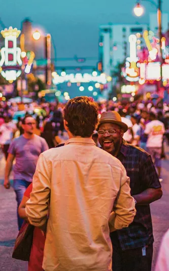 Contiki travellers exploring Broadway in downtown Nashville, Tennessee, surrounded by live music venues and neon signs on the Nashville to Dallas Tour