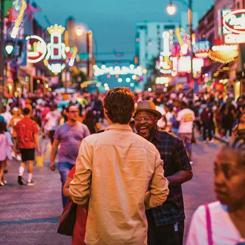 Contiki travellers exploring Broadway in downtown Nashville, Tennessee, surrounded by live music venues and neon signs on the Nashville to Dallas Tour