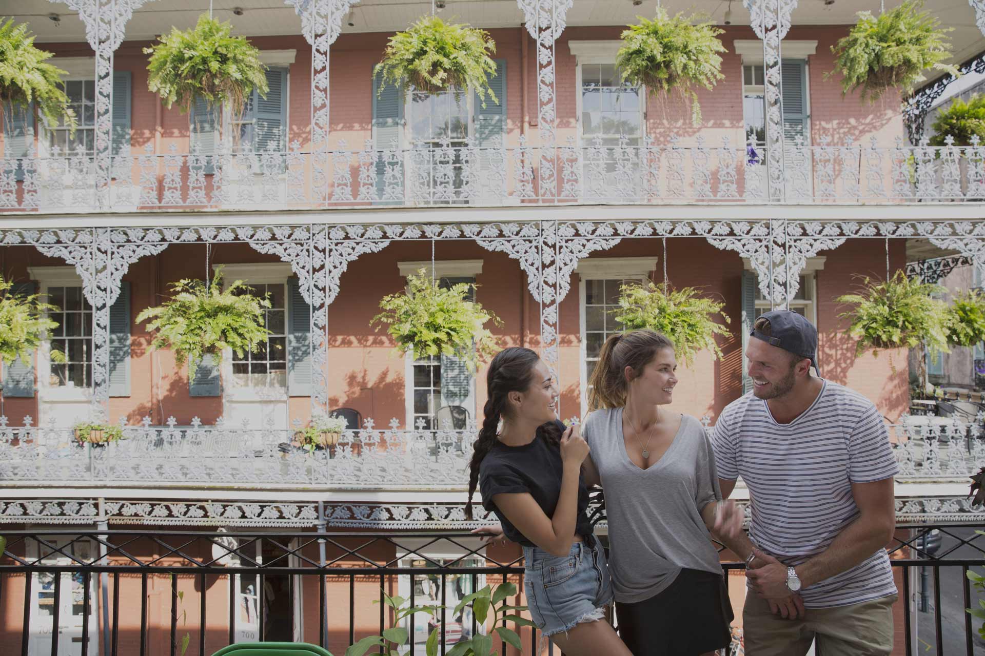 Three tourists standing in front of old traditional city house in New Orleans, USA