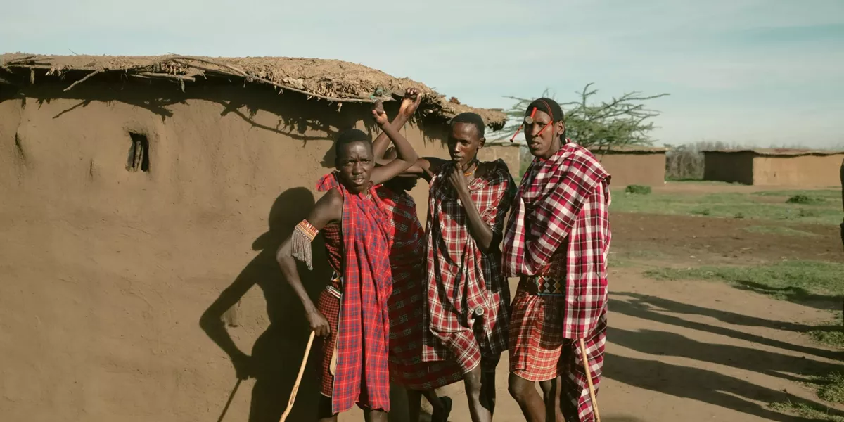 Group meet Maasai community members in a traditional village during Contiki's Kenya: Maasai Mara & Safari Tour