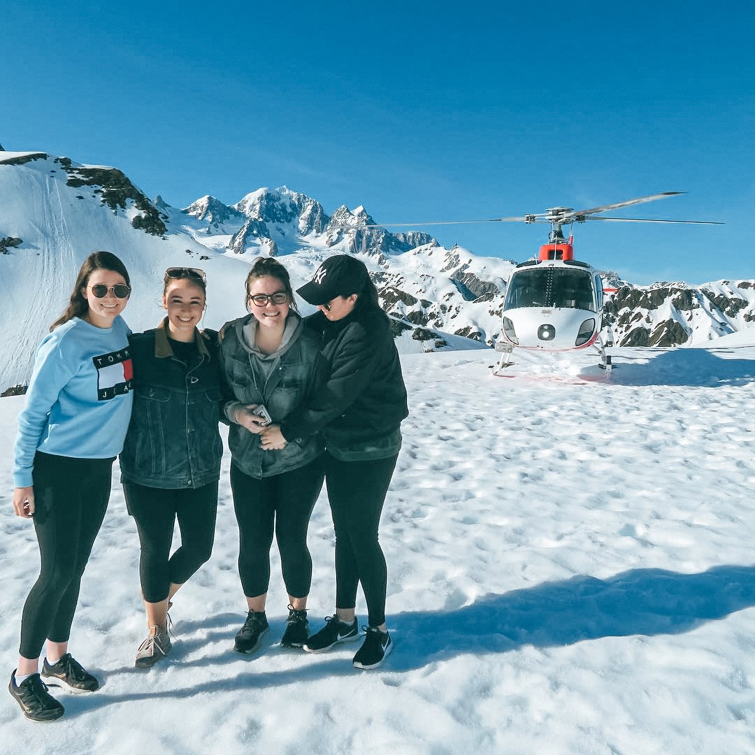 Travellers in front of helicopter before their scenic flight in over the Franz Josef Glacier, New Zealand 