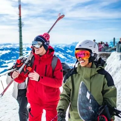 People with skis and snowboards in the winter mountains 