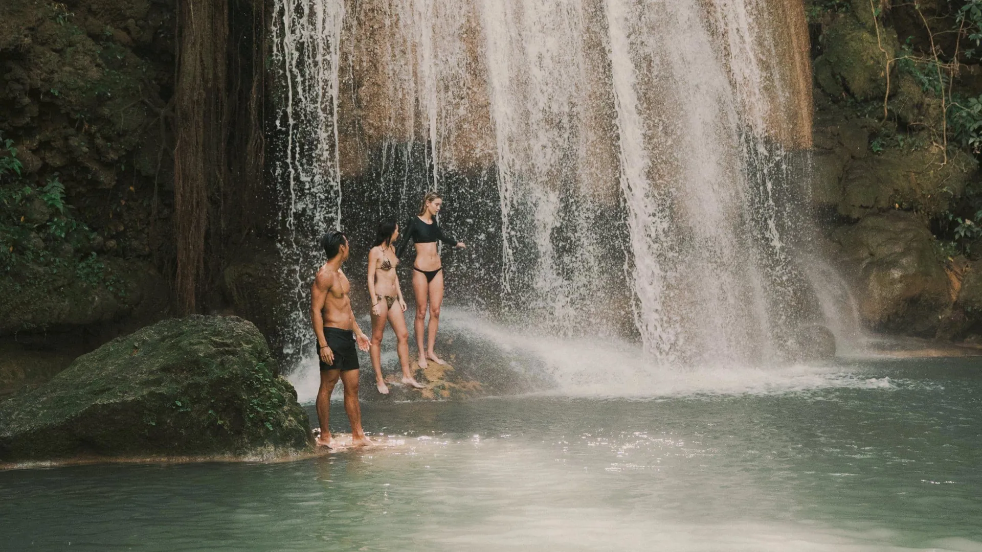 Travellers swimming beneath a tropical waterfall in Northern Thailand - Contiki Chiang Mai & Pai Tour