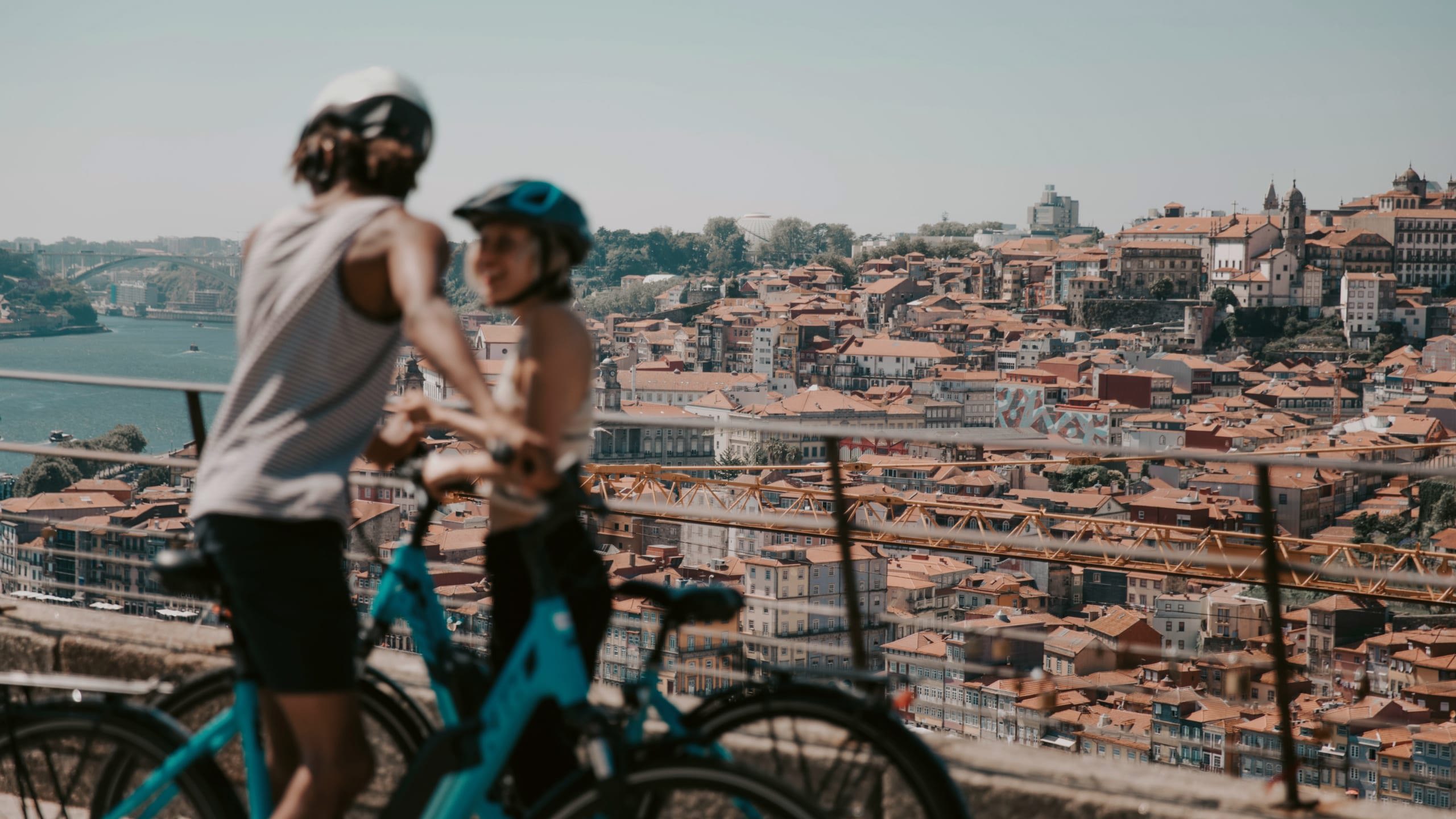 Two people cycling above Porto with panoramic views of the historic city and Douro River on Contiki's Lisbon to Barcelona Tour