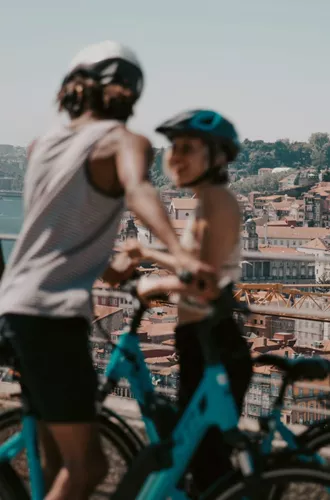 Two people cycling above Porto with panoramic views of the historic city and Douro River on Contiki's Lisbon to Barcelona Tour