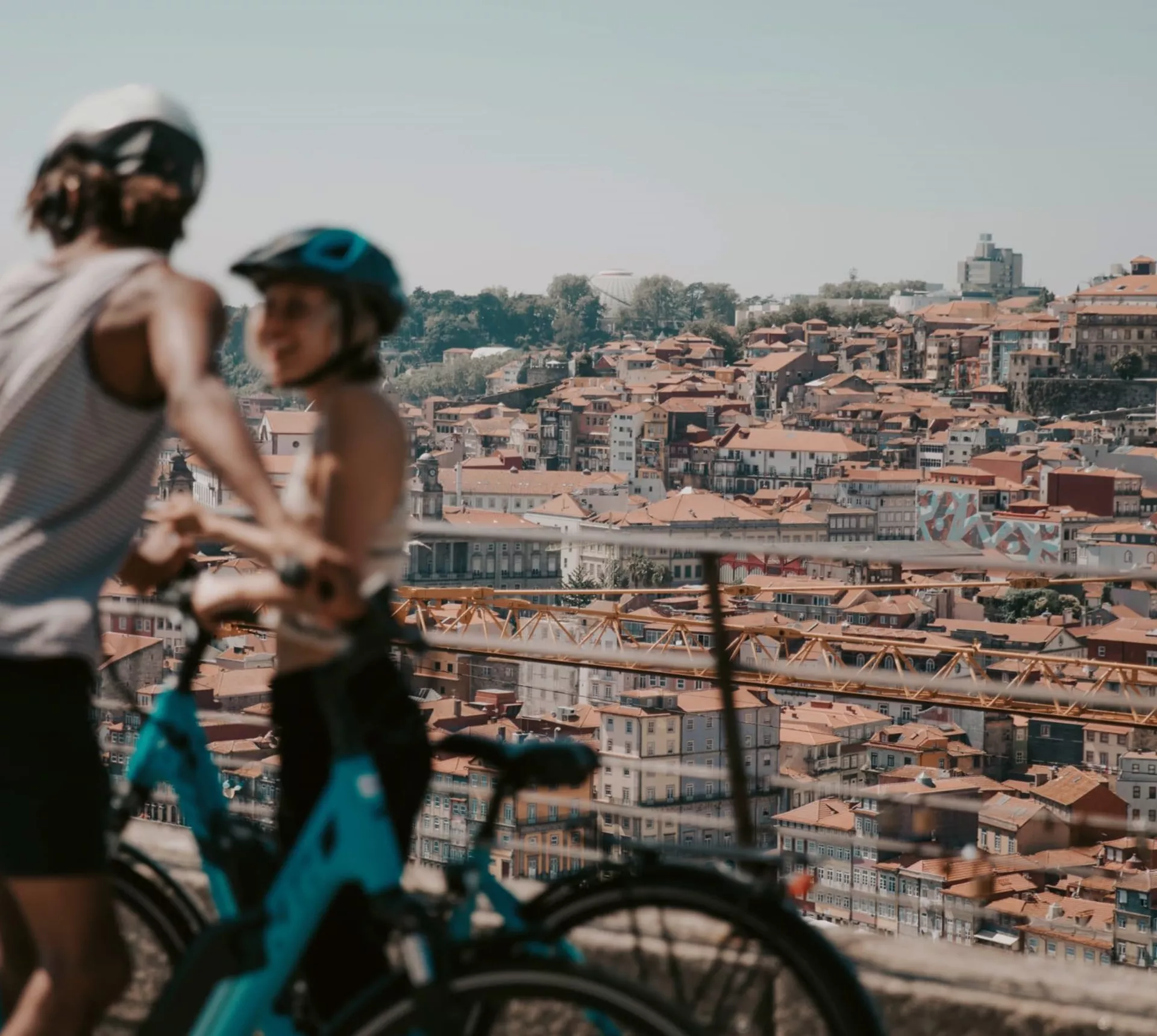 Two people cycling above Porto with panoramic views of the historic city and Douro River on Contiki's Lisbon to Barcelona Tour
