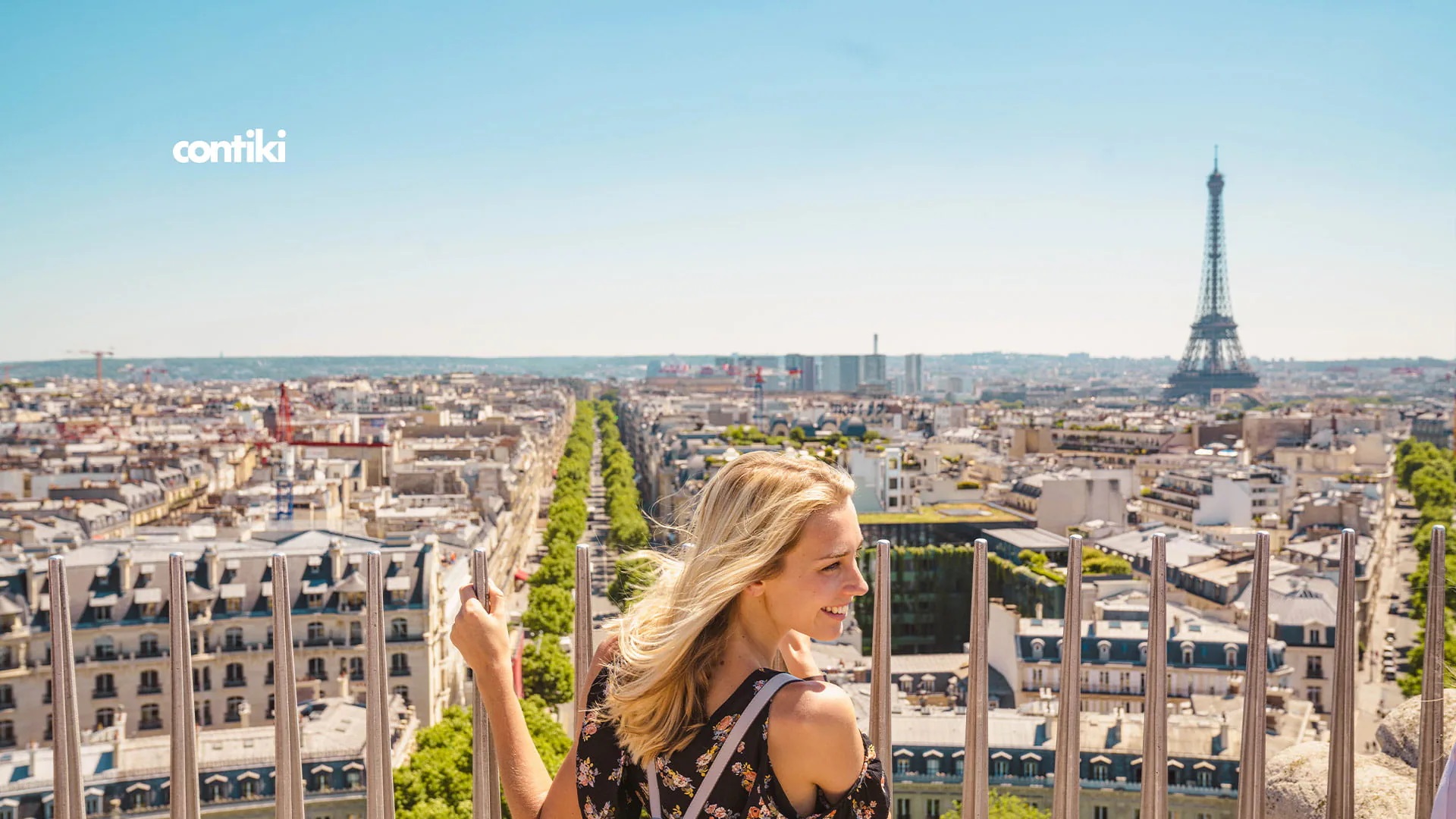 A woman holding onto a fence in Paris