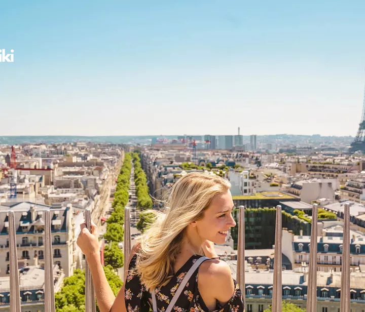 A woman holding onto a fence in Paris