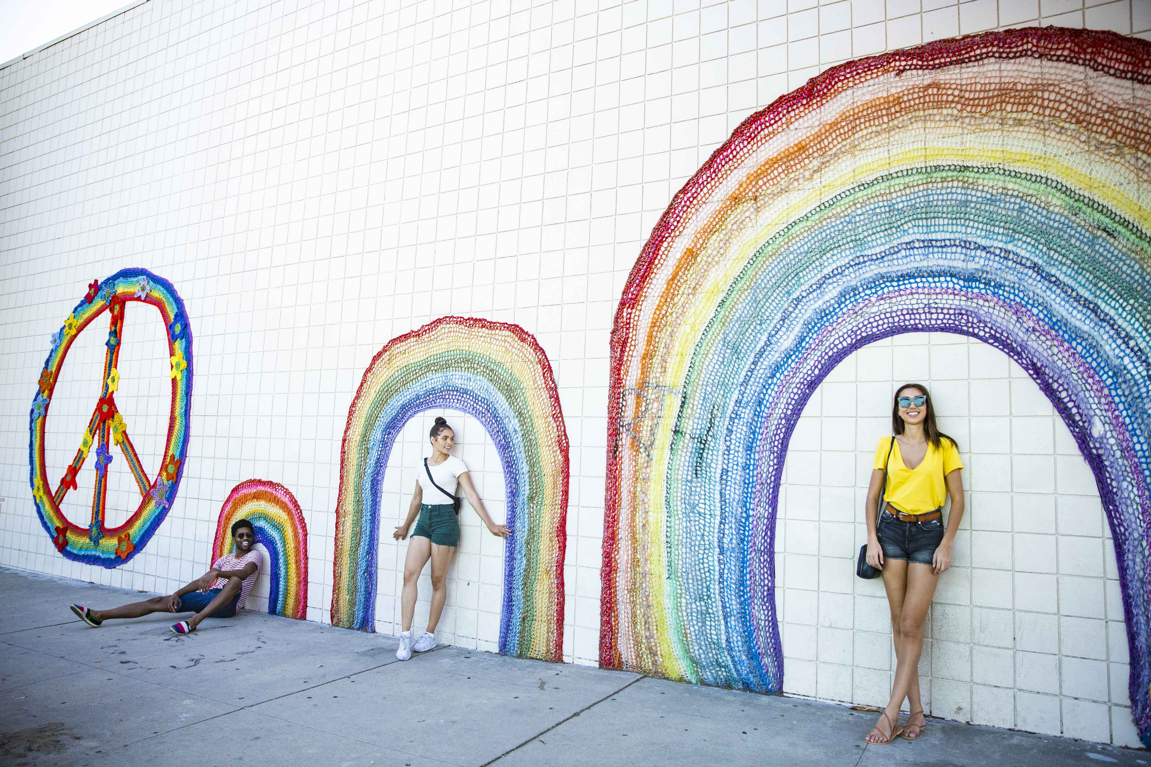 Trio Taking Photo Leaning Against Pride Wall Art
