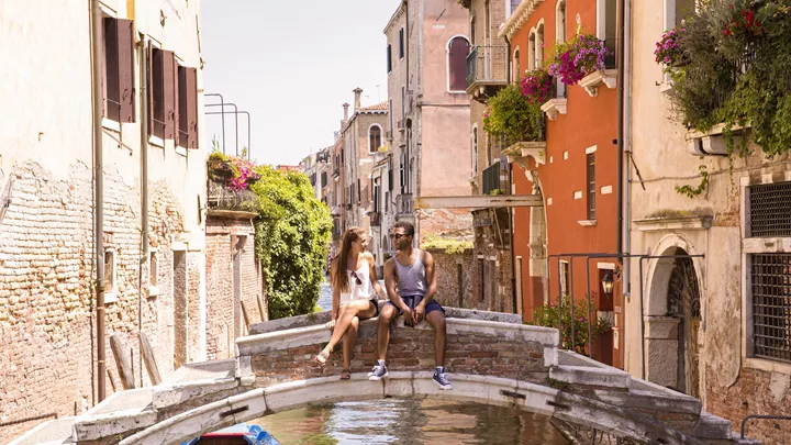 Travellers on a canal bridge in Venice, Italy