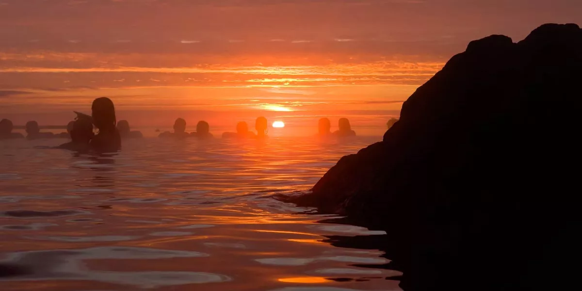 People Enjoying A Sunset In A Warm Natural Pool