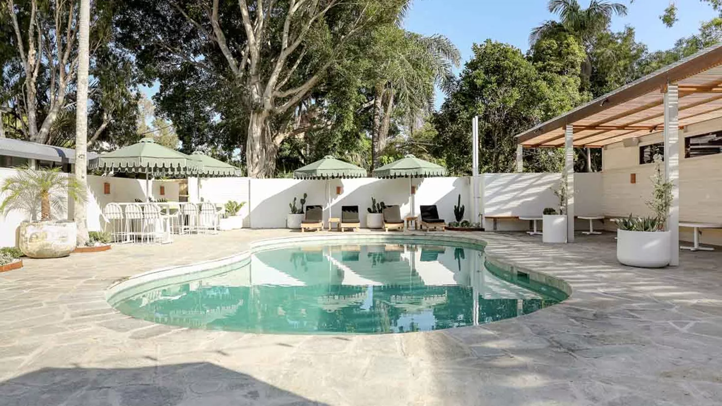 Swimming Pool Surrounded By Sunbeds And Umbrellas