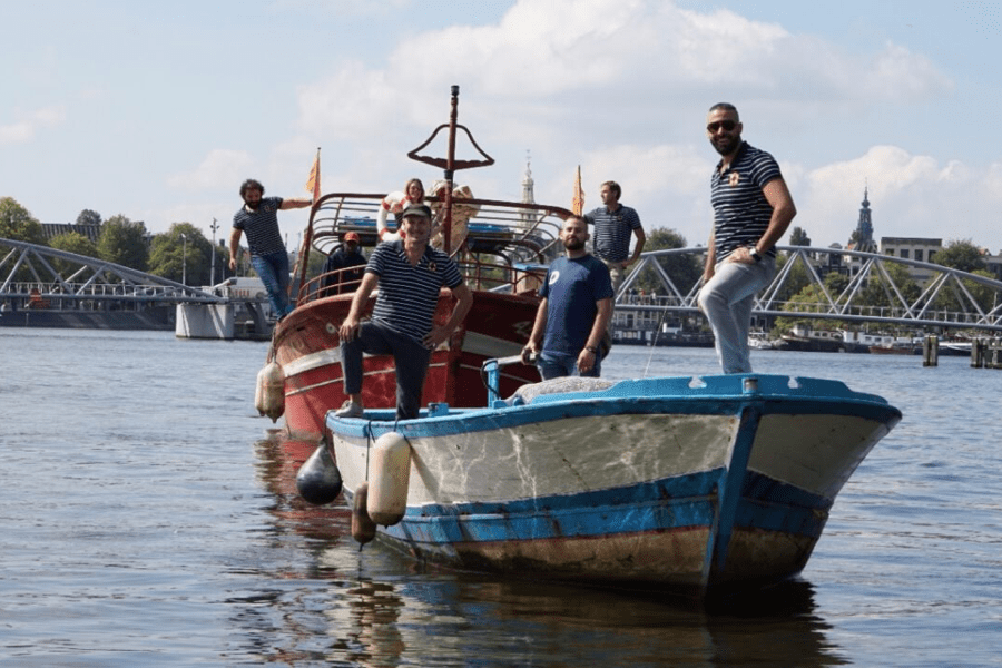 A group of men standing on top of a boat in the water