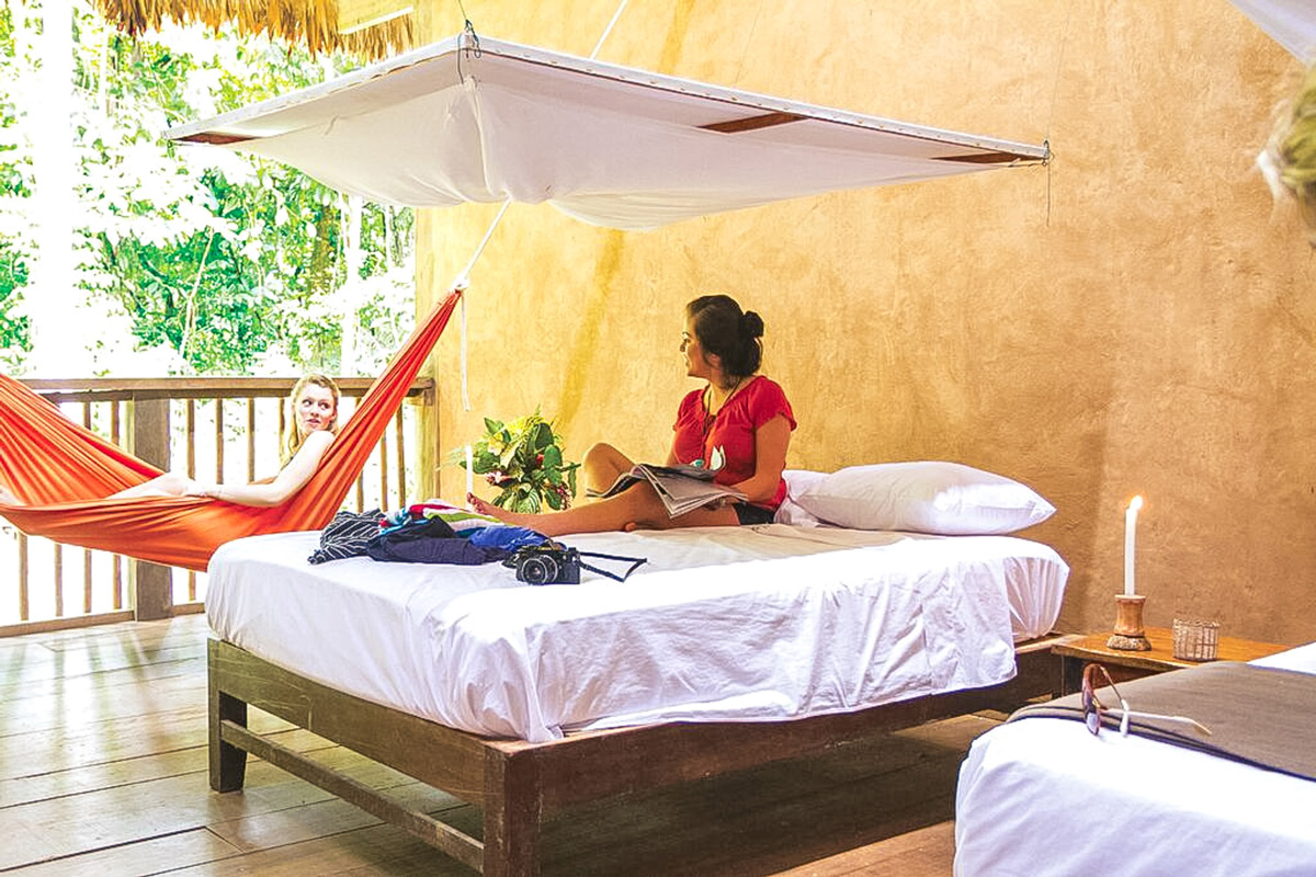 Two Women Talking One On The Bed One In A Hammock