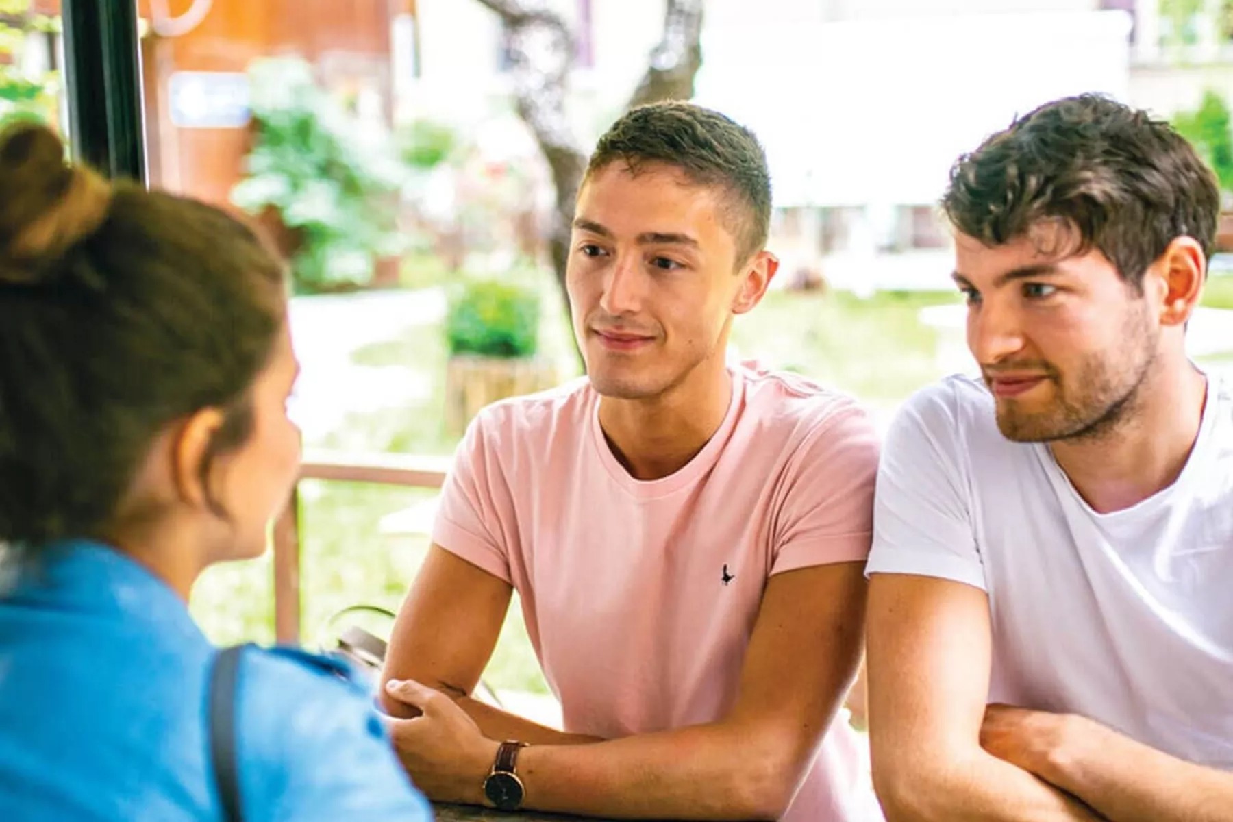 Young people in t-shirts sitting and smiling