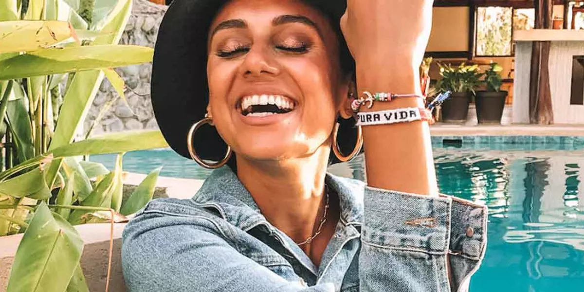 Woman Laughing Wearing Black Large Hat Bracelet Saying Buena Vida