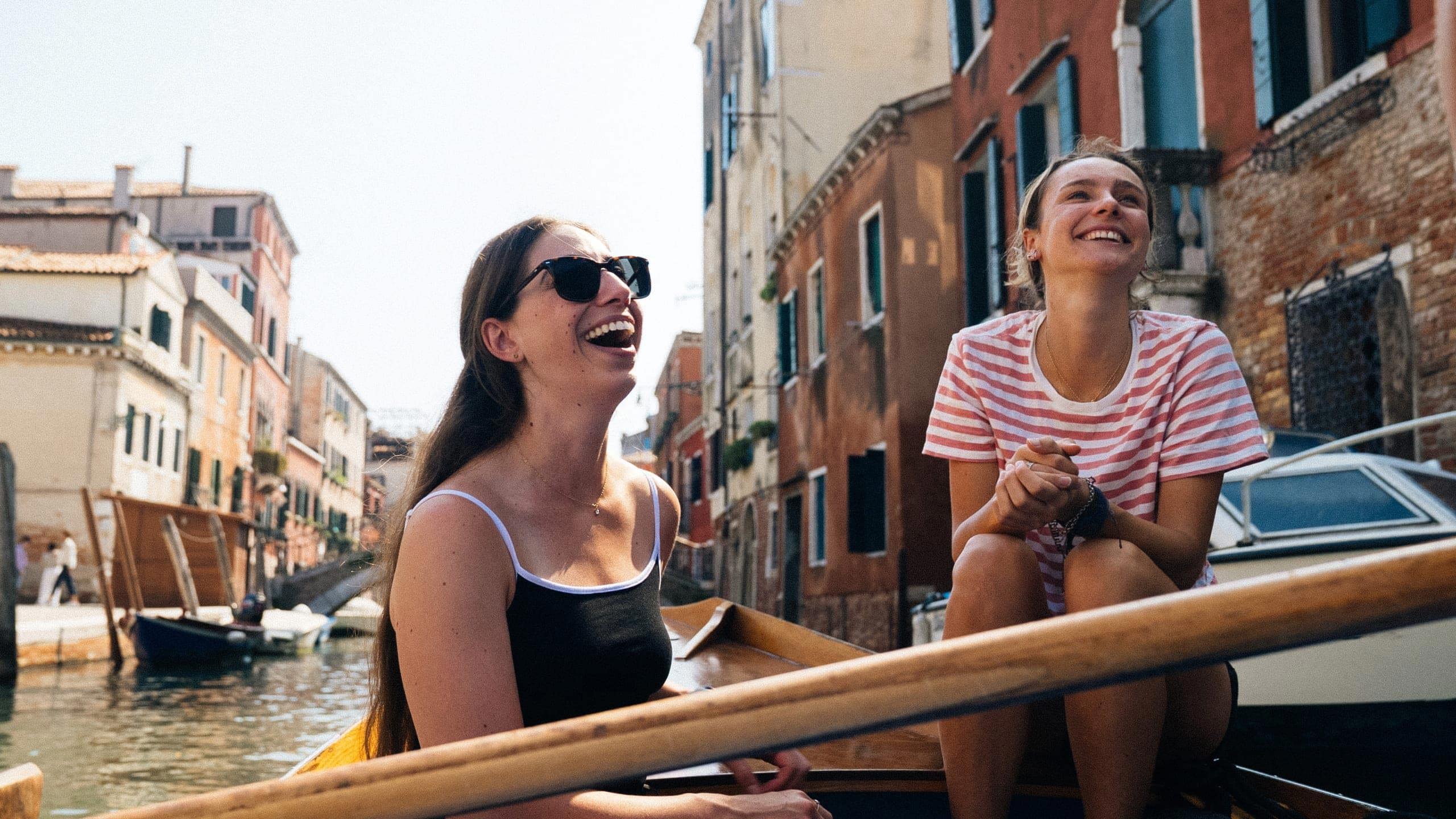 Travellers riding a gondola through the canals of Venice, Italy, during Contiki's Best of Italy Tour