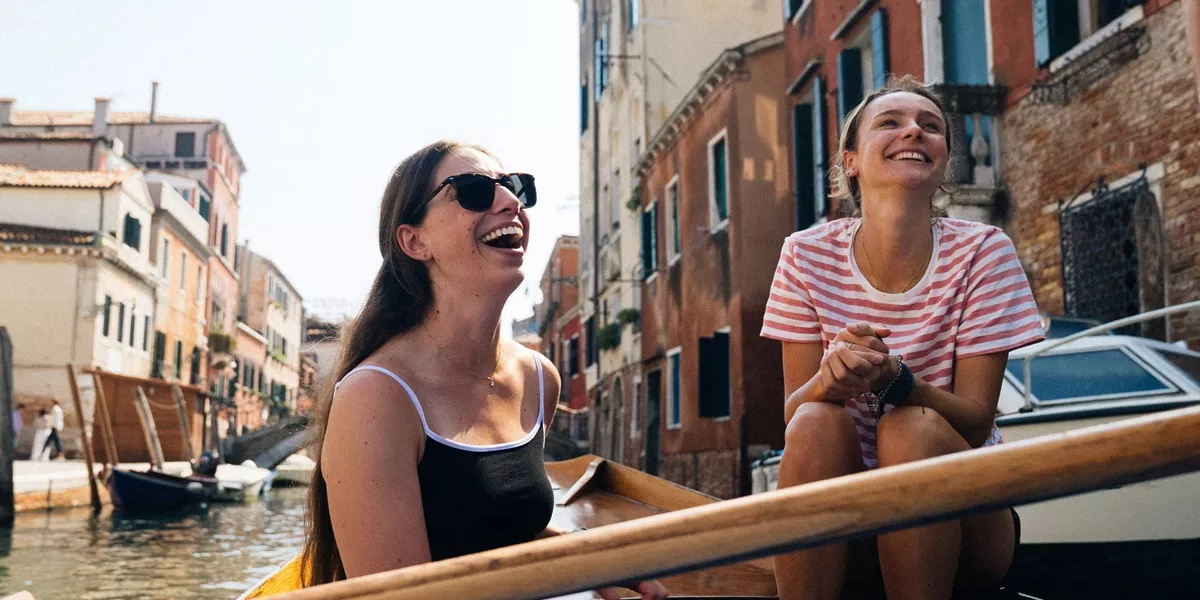 Travellers riding a gondola through the canals of Venice, Italy, during Contiki's Best of Italy Tour