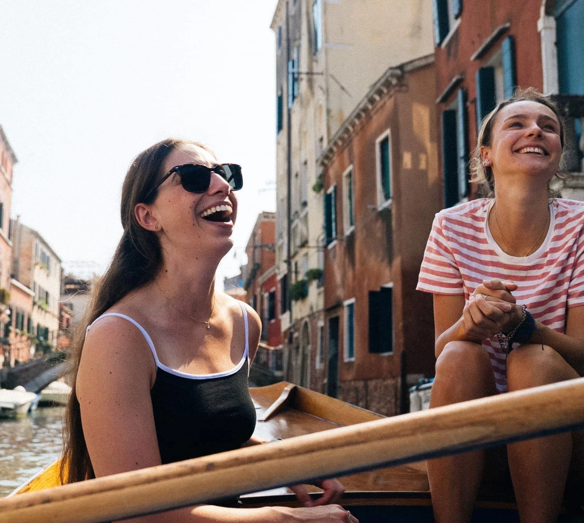Travellers riding a gondola through the canals of Venice, Italy, during Contiki's Best of Italy Tour