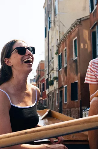 Travellers riding a gondola through the canals of Venice, Italy, during Contiki's Best of Italy Tour