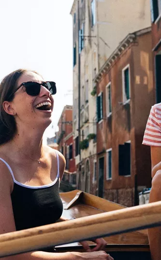 Travellers riding a gondola through the canals of Venice, Italy, during Contiki's Best of Italy Tour