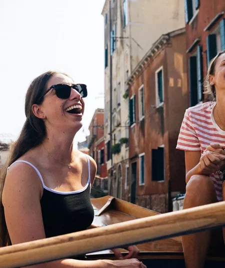 Travellers riding a gondola through the canals of Venice, Italy, during Contiki's Best of Italy Tour