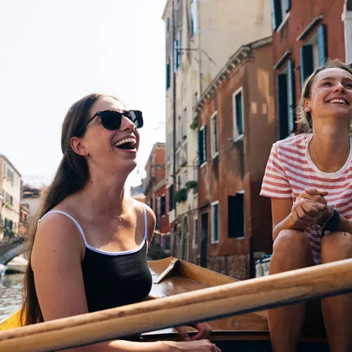 Travellers riding a gondola through the canals of Venice, Italy, during Contiki's Best of Italy Tour