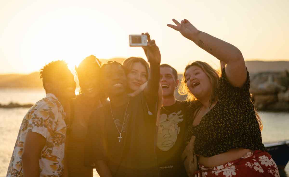 Group Taking Selfie At Sunset