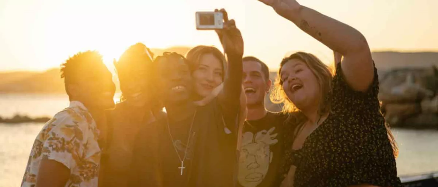 Group Taking Selfie At Sunset