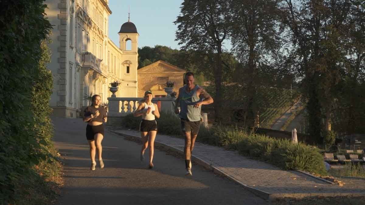 Three people are jogging in front Chateau