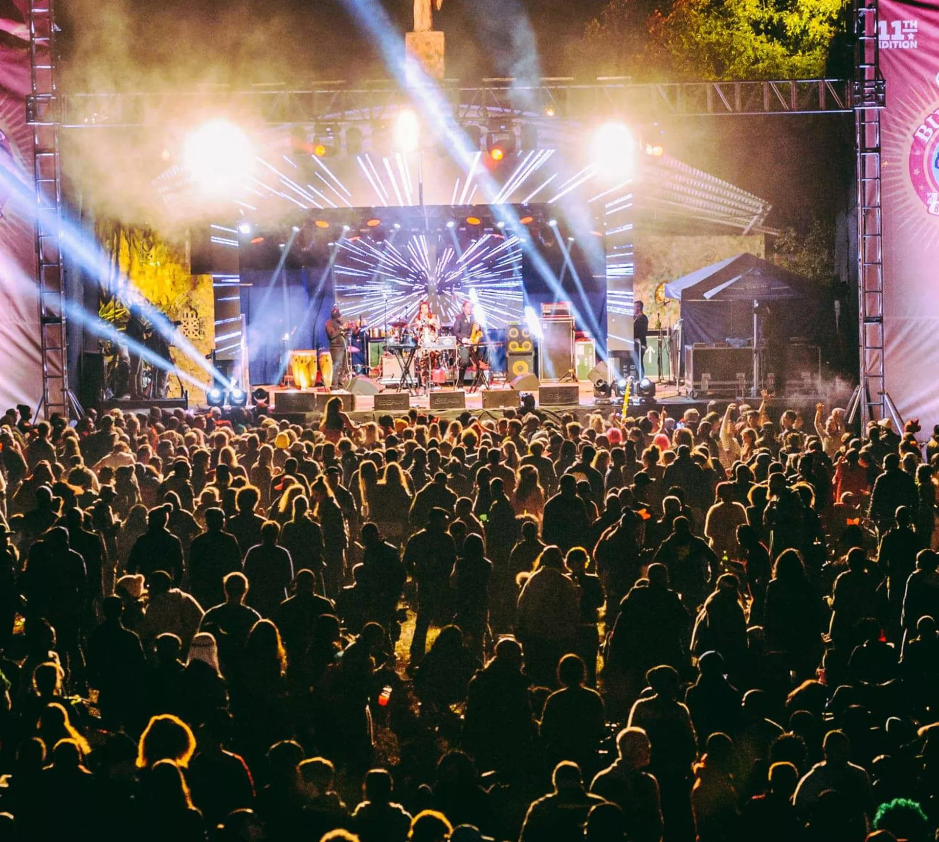 Large crowd watching a live performance on the main stage at MTN Bushfire Festival in Eswatini with dramatic blue stage lighting at night - Contiki Kruger Safari & Bushfire Festival