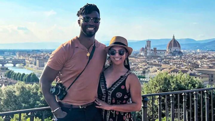 Two travellers posing for a picture at a viewpoint overlooking Florence