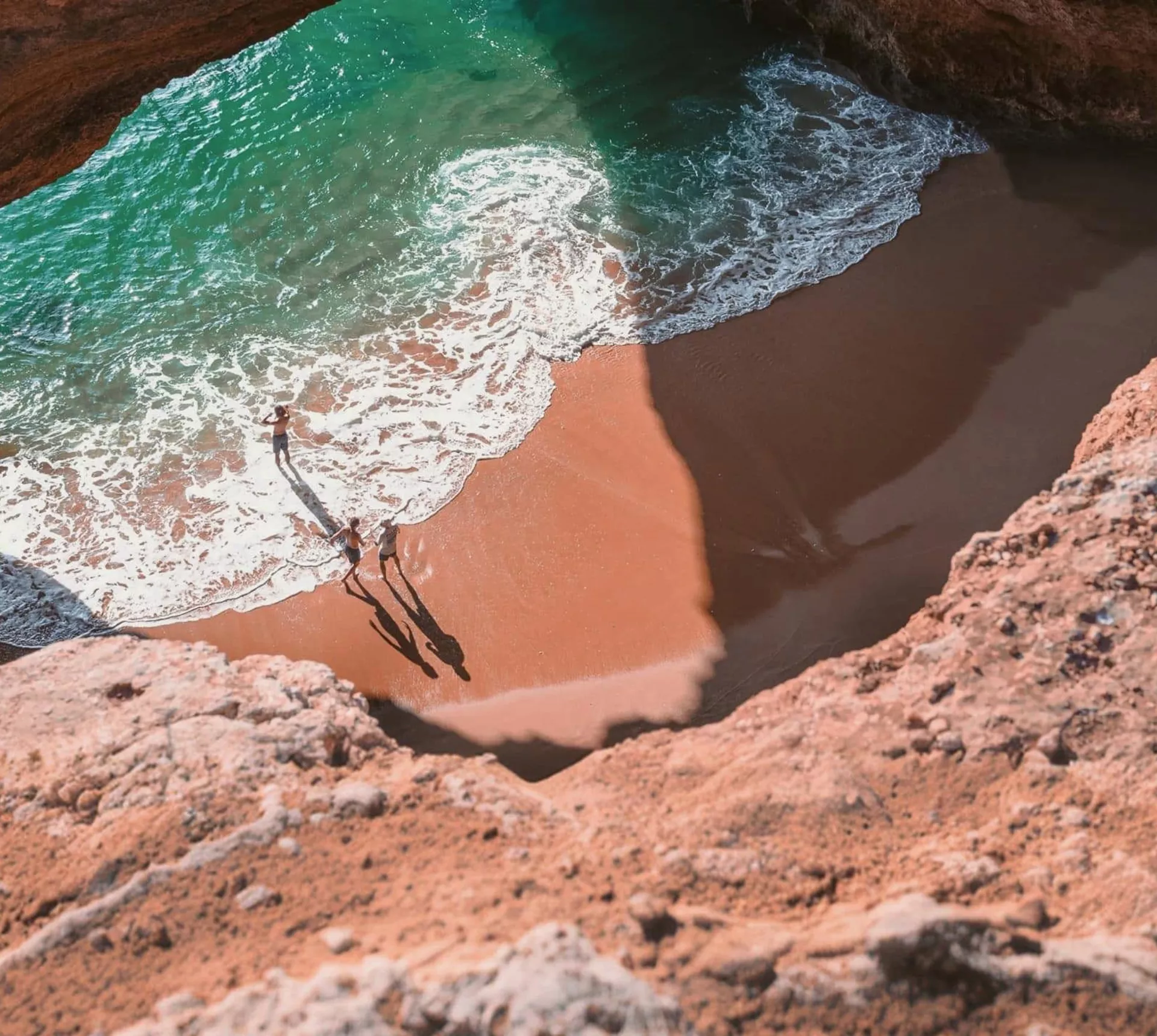 Contiki travellers exploring Benagil Cave on Portugal’s Algarve coast, enjoying the secluded beach and turquoise waters on the Madrid to Lisbon Tour