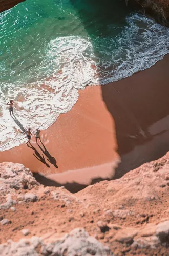 Contiki travellers exploring Benagil Cave on Portugal’s Algarve coast, enjoying the secluded beach and turquoise waters on the Madrid to Lisbon Tour