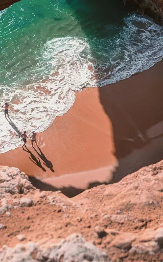 Contiki travellers exploring Benagil Cave on Portugal’s Algarve coast, enjoying the secluded beach and turquoise waters on the Madrid to Lisbon Tour