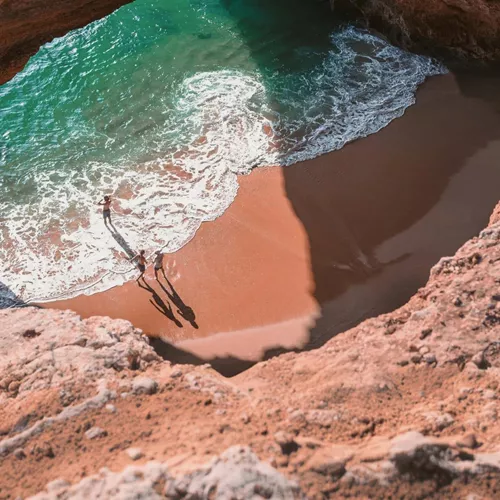 Contiki travellers exploring Benagil Cave on Portugal’s Algarve coast, enjoying the secluded beach and turquoise waters on the Madrid to Lisbon Tour