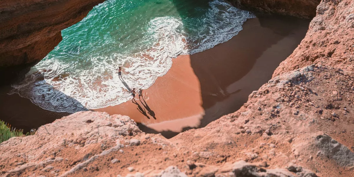 Contiki travellers exploring Benagil Cave on Portugal’s Algarve coast, enjoying the secluded beach and turquoise waters on the Madrid to Lisbon Tour