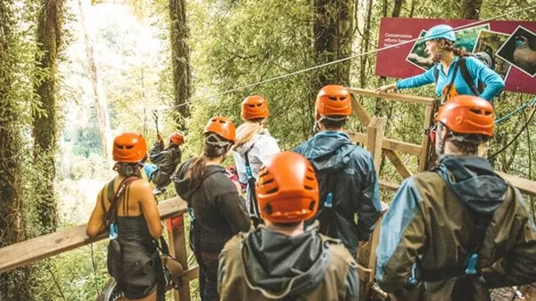 People in helmets waiting in line for the zip line